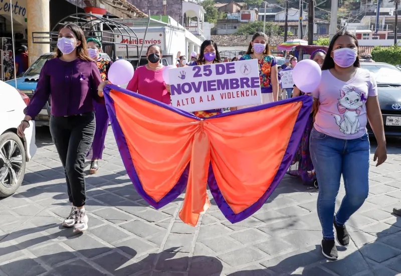 Mujeres marchando con moño naranja